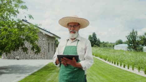 senior farmer using tablet in garden