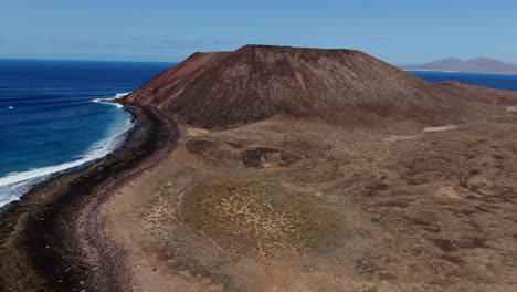 fantástica toma aérea en un día soleado y acercándose al volcán de la isla de los lobos, en las islas canarias