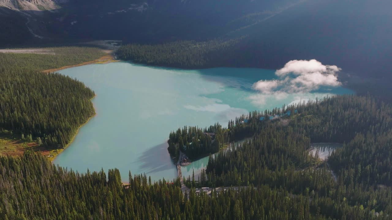 antena que se eleva sobre el lago louise entre bosques y montañas rocosas canadienses en fairmont hot springs, parque nacional de banff, alberta, canadá