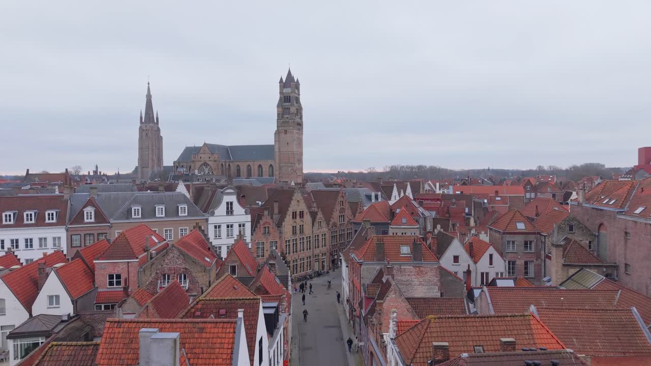 Una ripresa con drone che vola tra le affascinanti e pittoresche case di Bruges, rivelando gradualmente la storica Chiesa di San Giacomo e l'architettura medievale della città.
