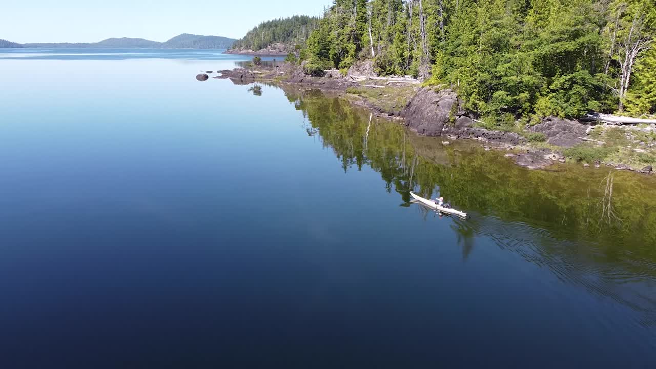 pintoresco kayakista en las aguas reflectantes del lago en el lago kennedy, isla laylee, isla de vancouver, canadá