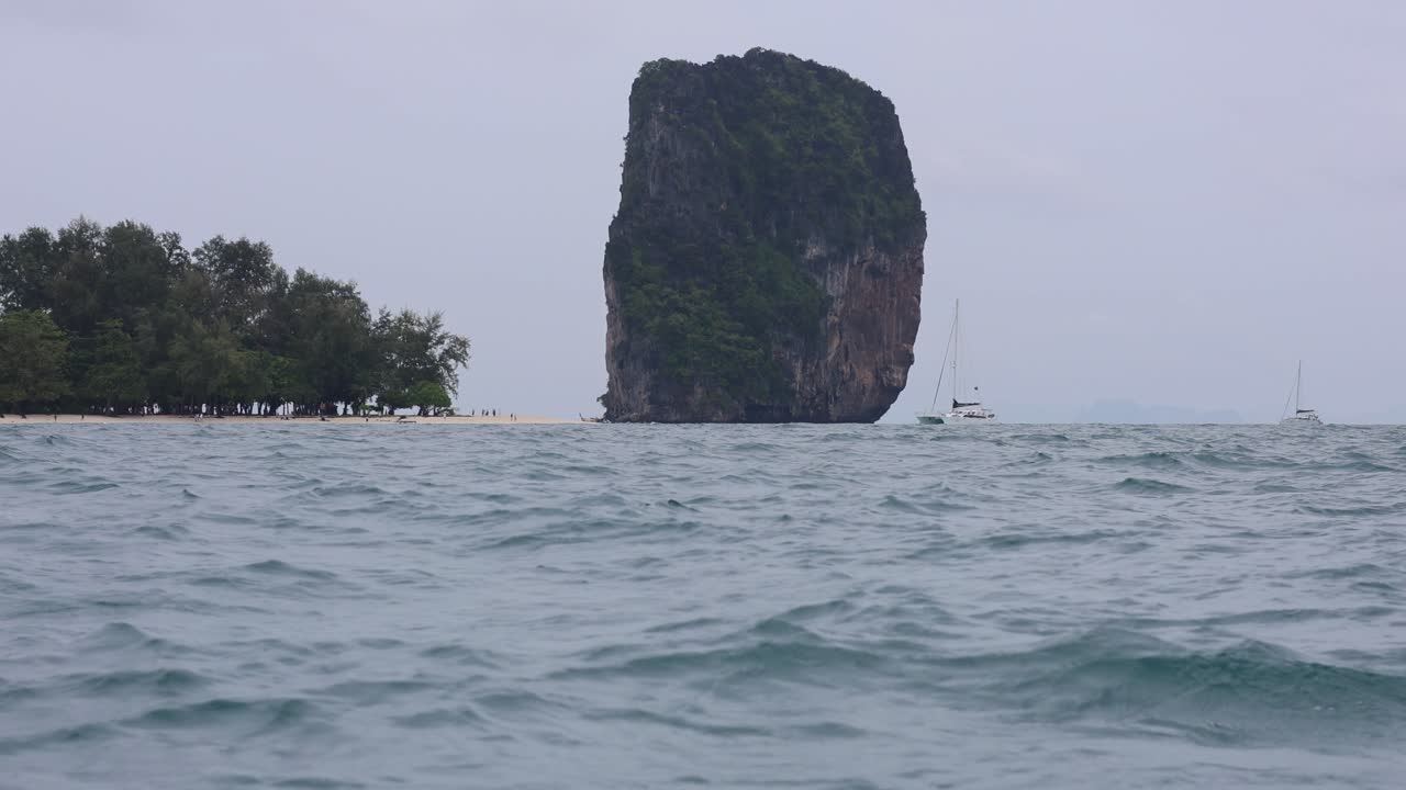 배가 크라비 물에서 상징적인 바위에 접근합니다.
