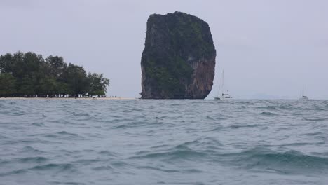 el barco se acerca a la roca icónica en las aguas de krabi.