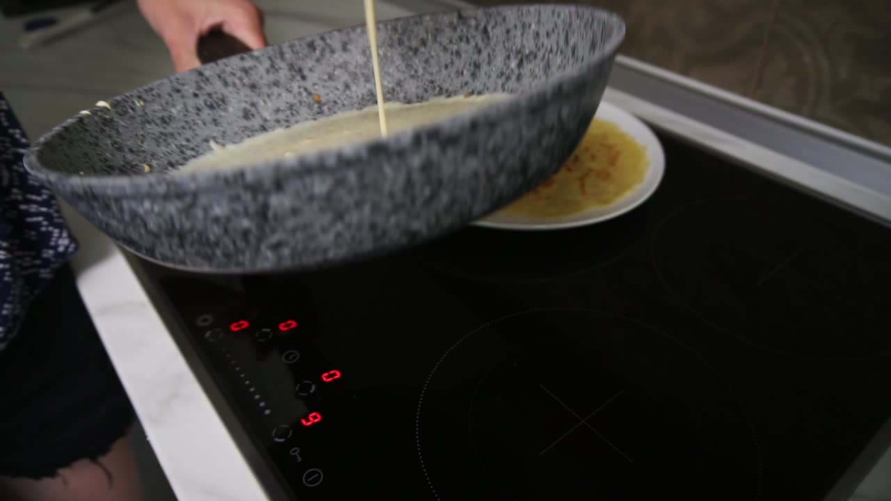 Close up view of female hands pouring pancake Mixed in a frying pan and spreading it around. Homemade food. Slow Motion shot