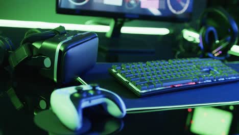 Video-of-computer-and-gaming-equipment-on-desk-with-copy-space-on-neon-background