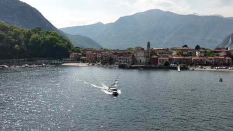 A-small-boat-cruises-through-Lago-Maggiore,-Italy,-summer-day