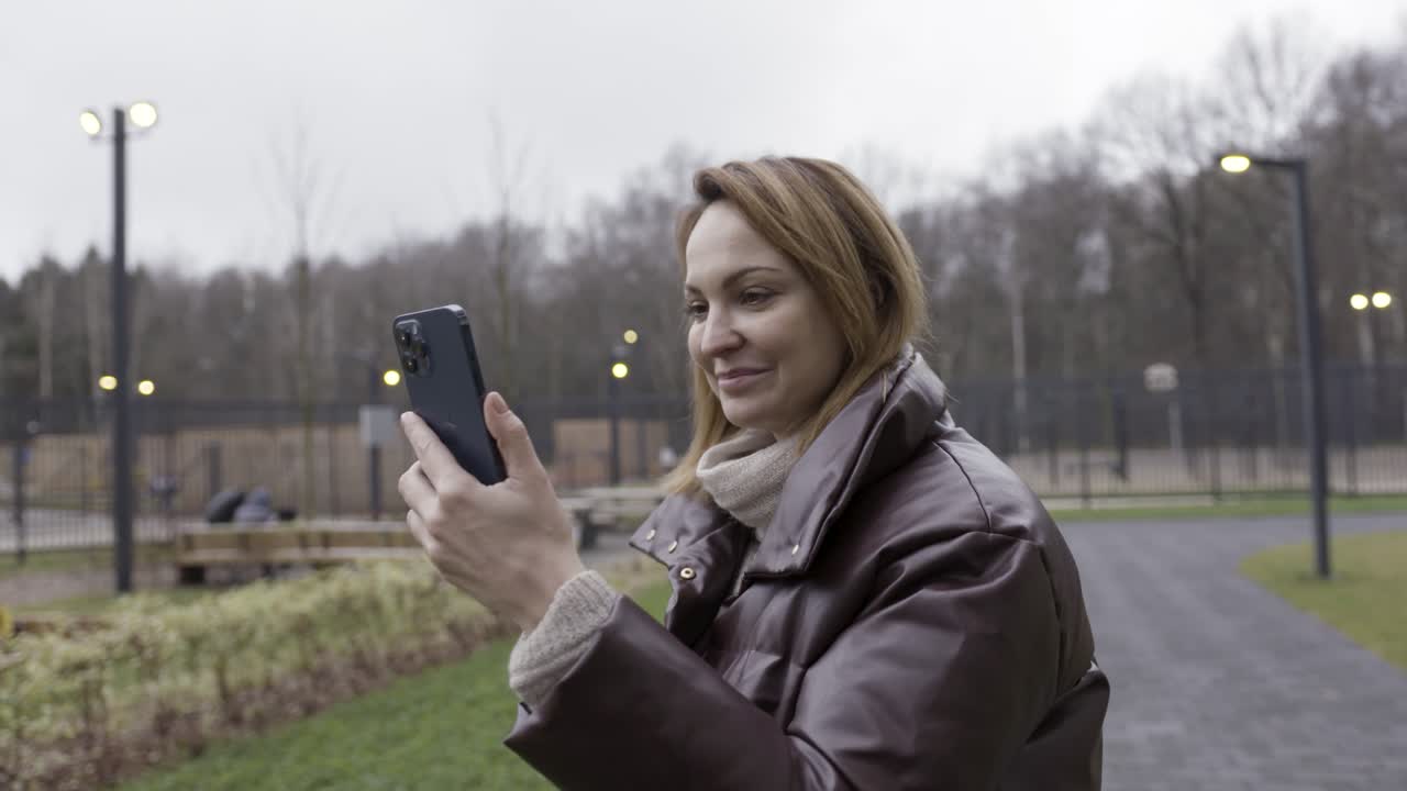 mujer usando el teléfono en un parque