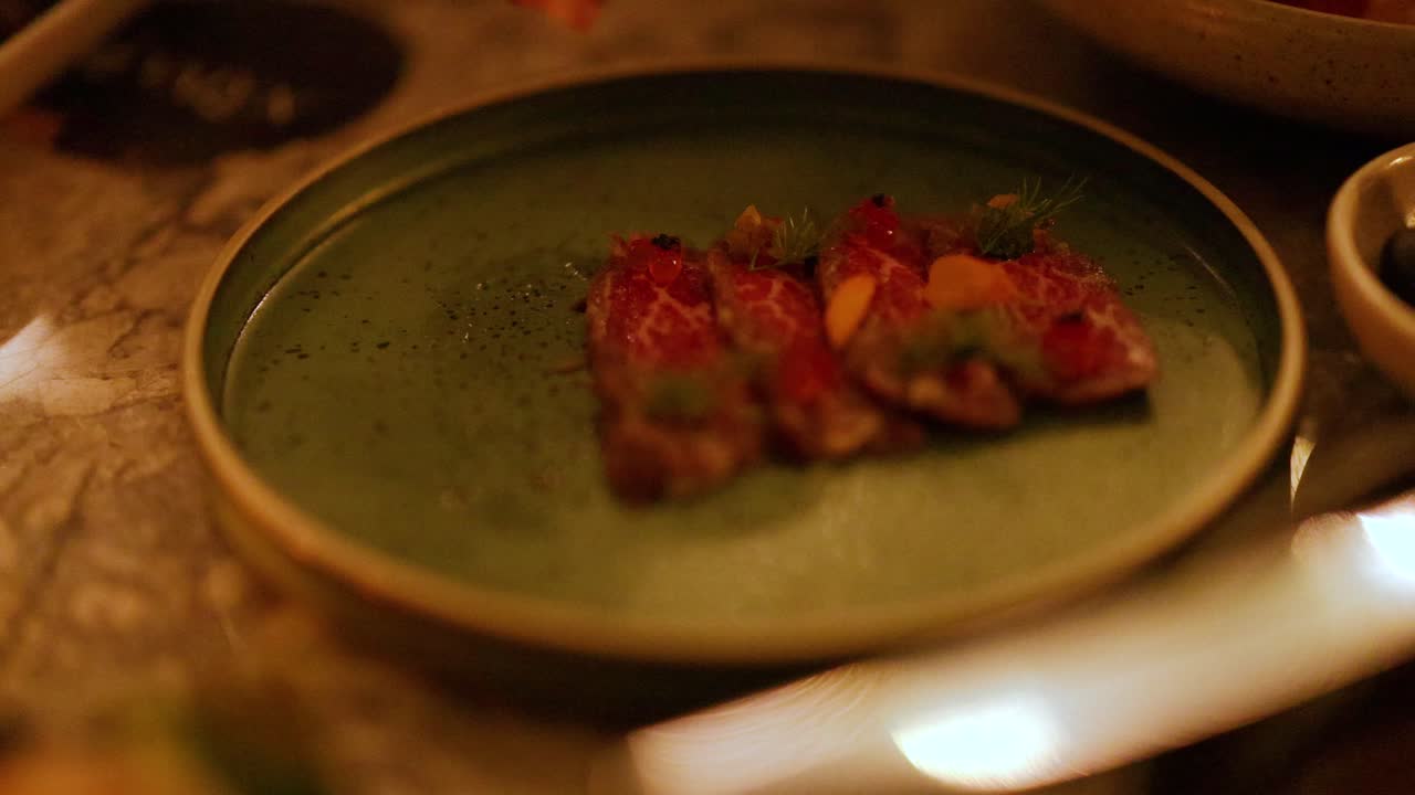 Slicing and plating beef tataki with garnish