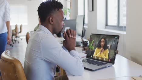 African-american-businessman-using-laptop-for-video-call-with-biracial-business-colleague