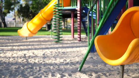 Nahaufnahme-Einer-Gelben-Rutsche-Auf-Einem-Leeren-Spielplatz-Im-Kinderpark-Mit-Bokeh-Und-Kopierraum-Im-Hintergrund