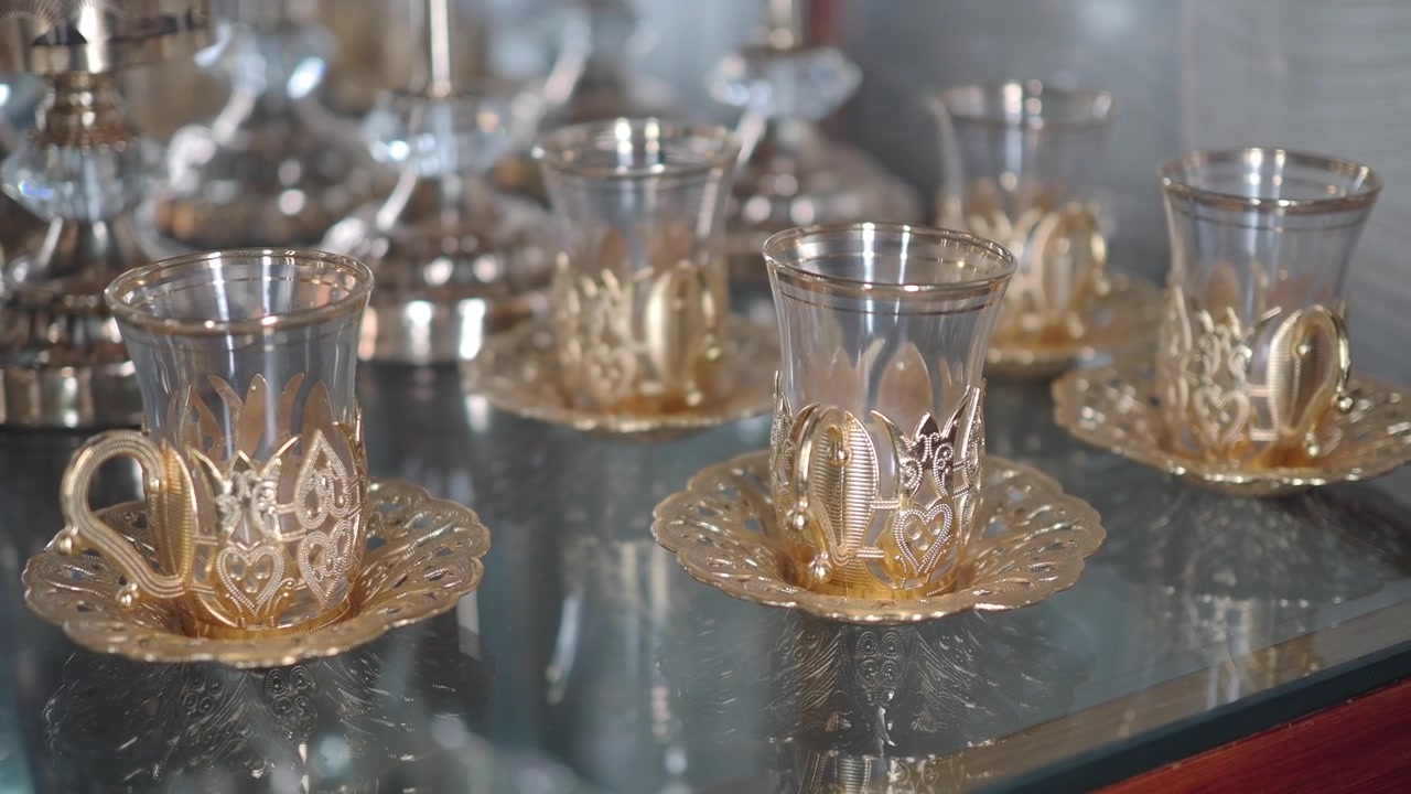Elegant Turkish Tea Glasses with Ornate Gold Holders on Display