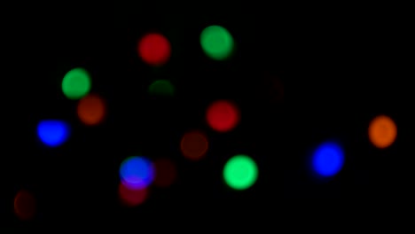 silueta borrosa del árbol de navidad con luces desfocalizadas brillantes fuera de foco. video vertical 4k interior de año nuevo de xmas con luces de colores de fondo. círculo brillante efecto bokeh parpadeante.