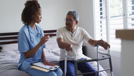 senior mixed race man with female doctor talking and holding pills