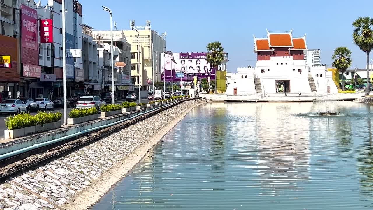 Berrak mavi gökyüzü altında, kanal, renkli binalar ve bir tapınak içeren canlı bir şehir manzarası