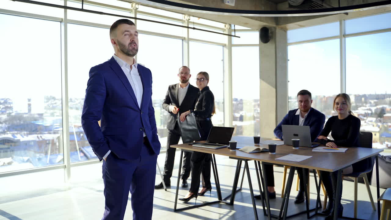 Male leader discussing work at office. Businessman in suit talking to business people colleagues or partners sitting at conference table