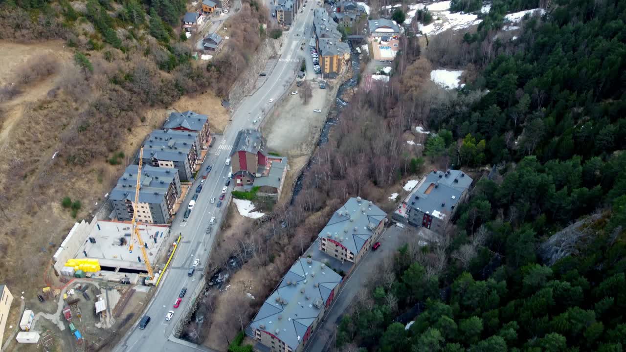 el dron desciende sobre el valle de la montaña con chalets de esquí y una ligera capa de nieve durante el día