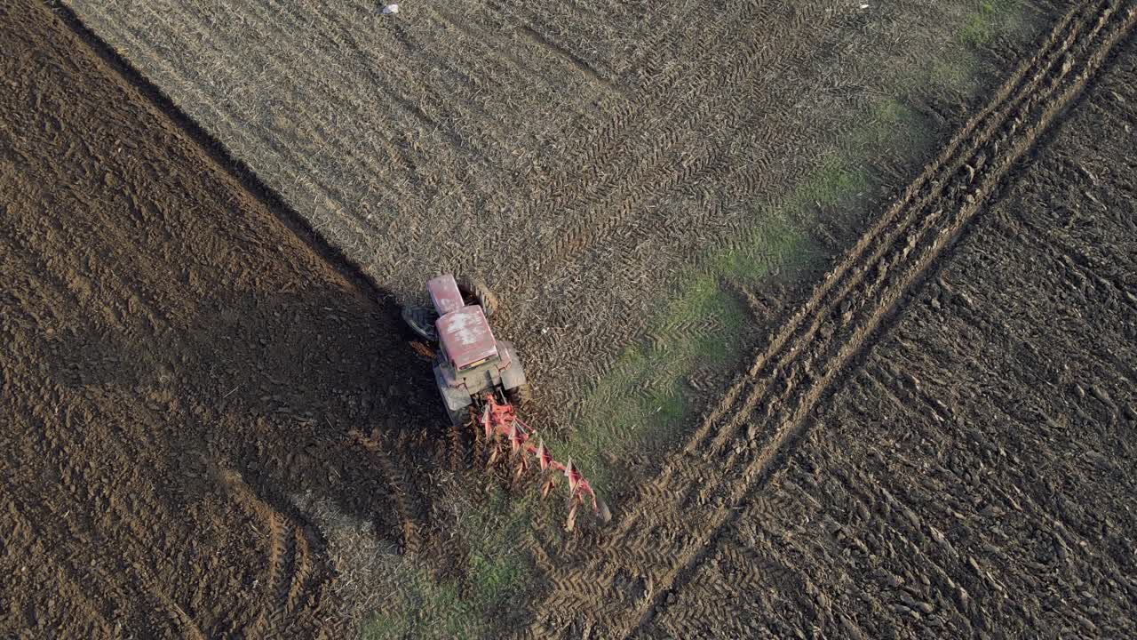 Premium stock video - Birds eye view of a tractor starting to plough a ...
