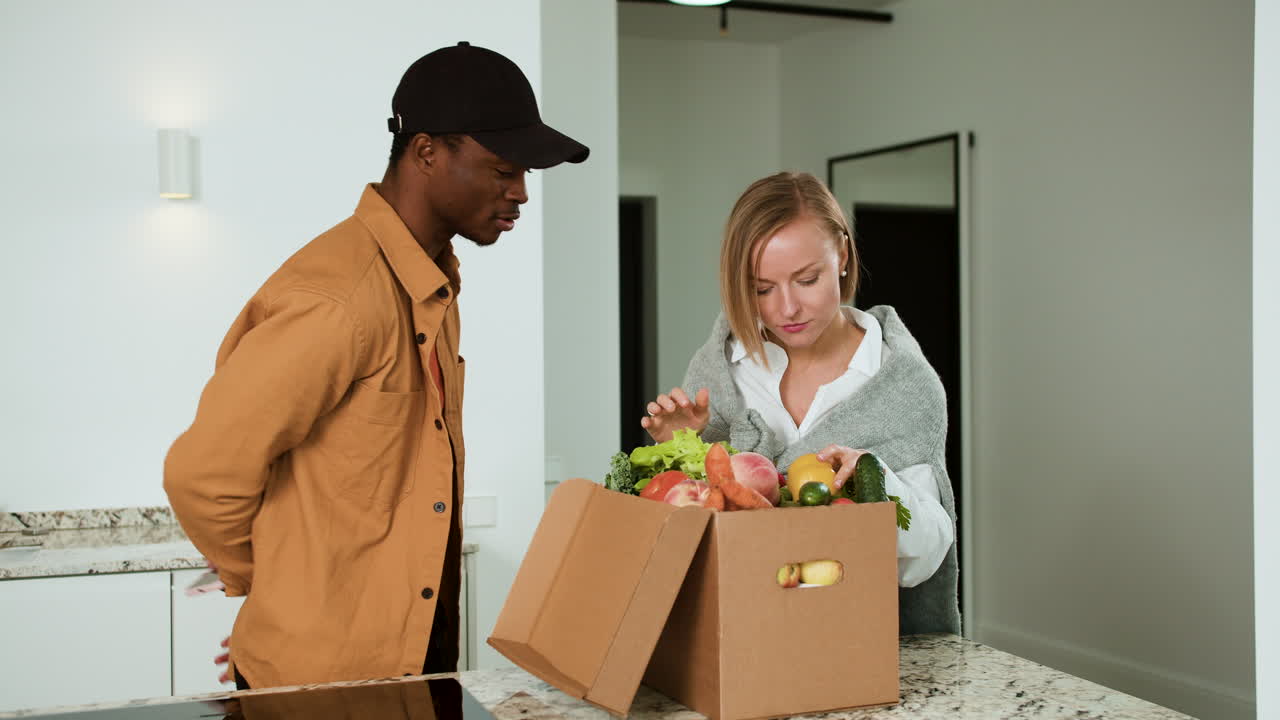 mujer recibiendo una caja de verduras
