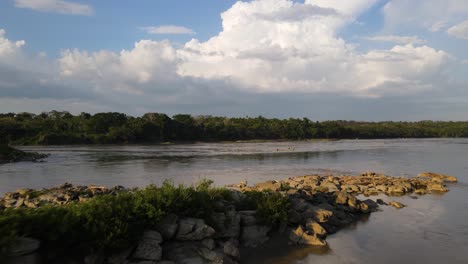 Aerial:-wide-river-flowing-through-rainforest-in-Central-America,-4K