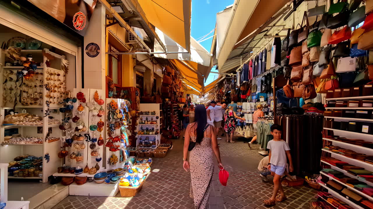 People and tourists walking and looking at products at a street market with many stalls with crafts and souvenirs from Chania in Crete Greece