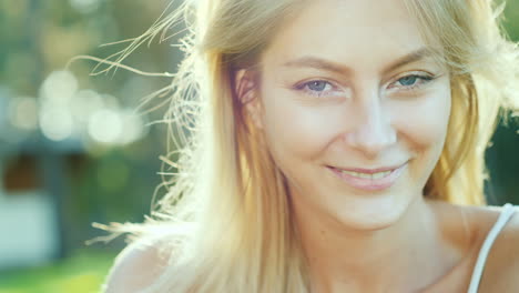 Retrato-De-Una-Bella-Joven-En-El-Pelo-Del-Sol-Iluminado-Por-El-Sol-Sonriendo-A-La-Cámara-Lenta-Mot