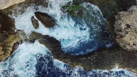 Una-Toma-Aérea-De-Olas-Rompiendo-En-Las-Rocas