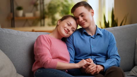 Happy couple relaxing together on a couch at home