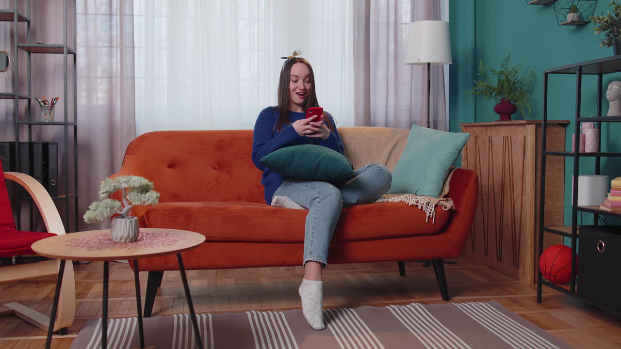 mujer joven adulta en casa usar teléfono móvil celular escribir navegación decir wow sí descubrió gran gran ganancia