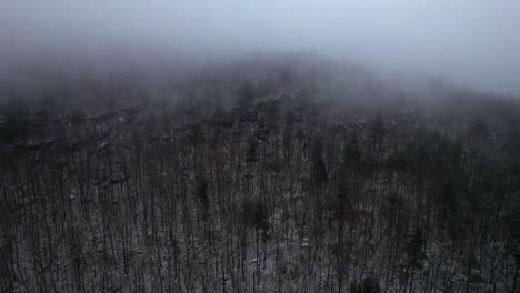 aerial drone video footage of a foggy nightf in the snowy appalachian mountains during winter, in the catskill mountains sub-range