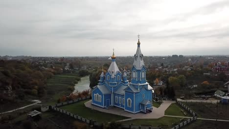 drone view of a wooden, blue church in ukraine