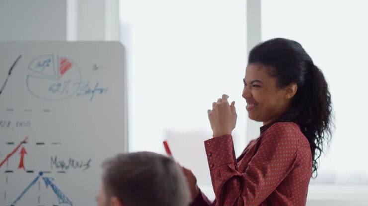 Femme afro joyeuse riant lors d'une présentation professionnelle en salle de conférence