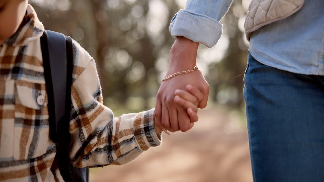 A mother and son holding hands outdoors