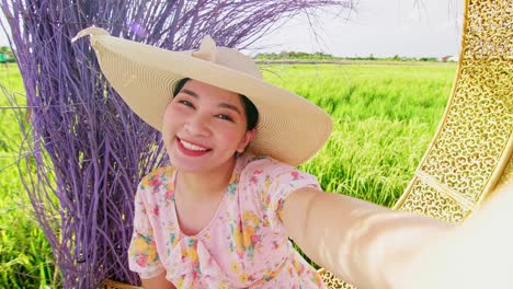 Portrait-of-Asian-adult-woman-relaxing-near-big-rice-field