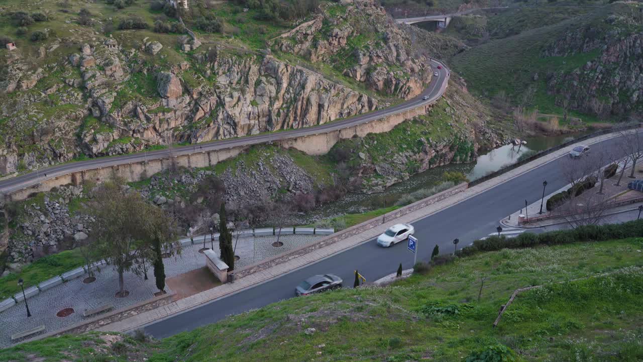 유럽의 스페인 톨레도(toledo)의 그림 같은 지역에서 산의 전망과 나무가 지나가는 자동차와 함께 도로의 수직 기울기