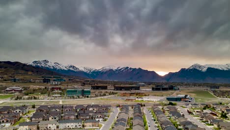 business park with office buildings and snowy mountains in the background on a gloomy dawn - aerial hyper lapse