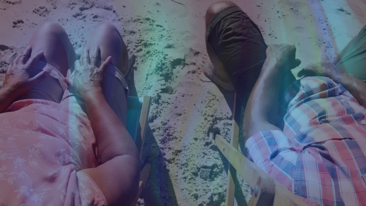 Senior couple reclining on wooden beach chairs on sand, showing animated travel icons