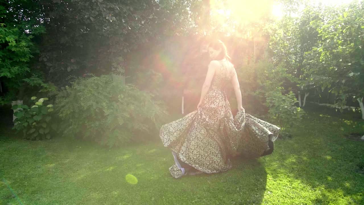 Woman in a Golden Dress in a Garden