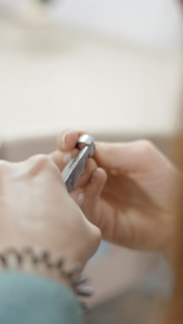 close-up of hands crafting jewelry with pliers