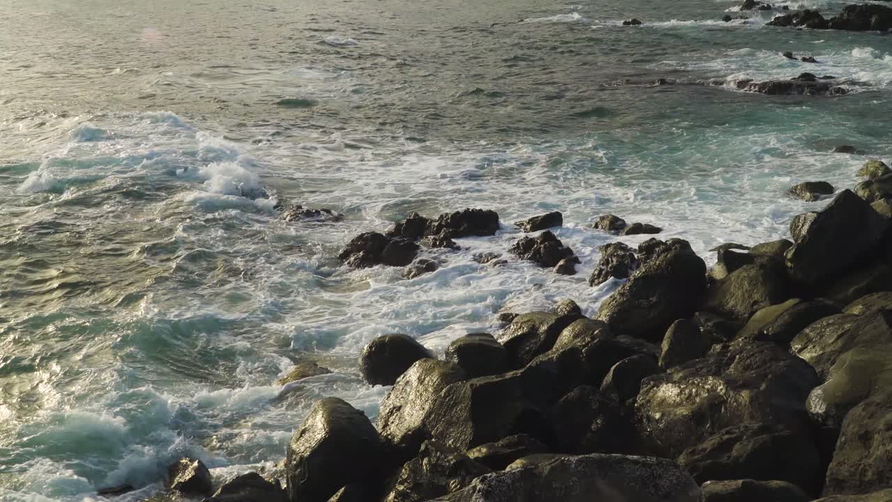 Atlantic Ocean waves crushing into the stone beaches of madeira island, Portugal.
