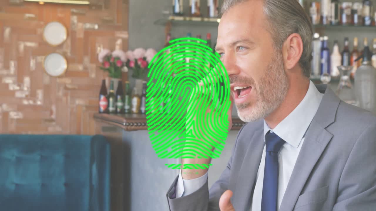Animation of fingerprint over caucasian businessman talking on smartphone