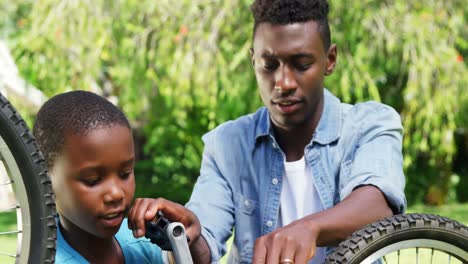 Man-repairing-a-bike-with-his-son