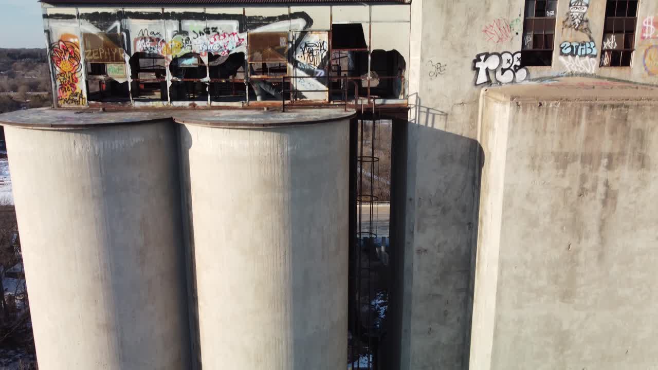 Drone descending down abandoned grain elevator tower