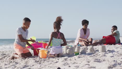 video of happy african american kids and parents playing on beach