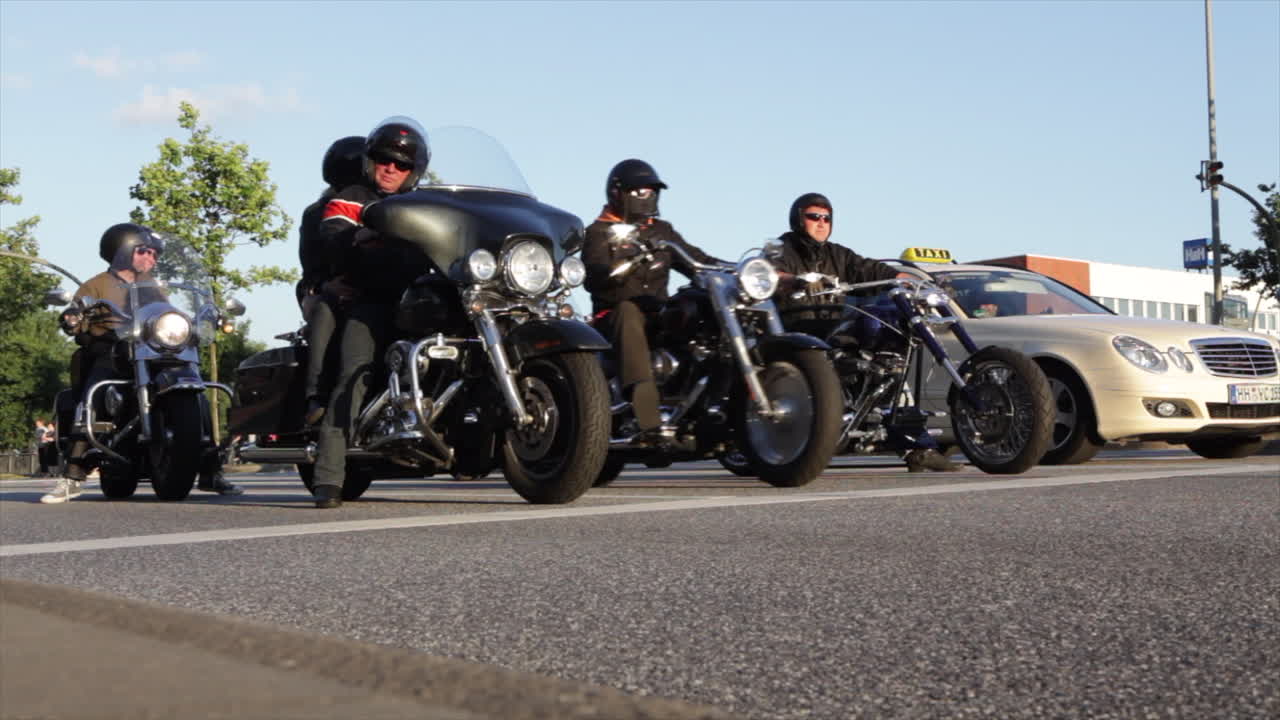 Motorbikes starting at a crossing on a big street at sunset