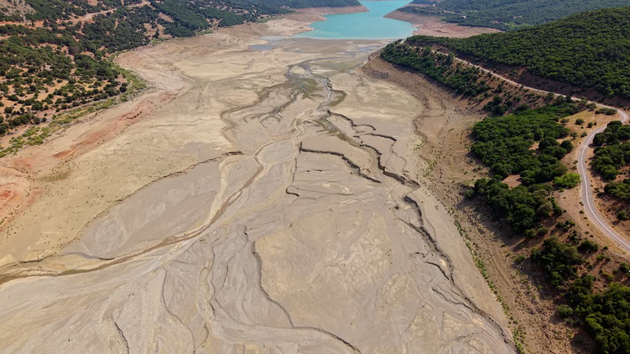 Topdown aerial of parched brown lakebed showing cracked texture and patterns in Greece