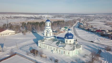 vista aérea de invierno de una iglesia ortodoxa rusa en un pequeño pueblo