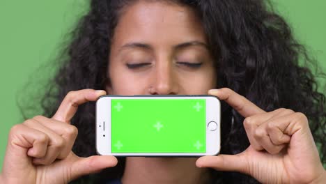 young beautiful hispanic businesswoman showing phone