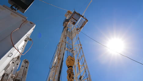 tower with drilling bour in the oil production site. footage at the wagon on the location. low angle view.
