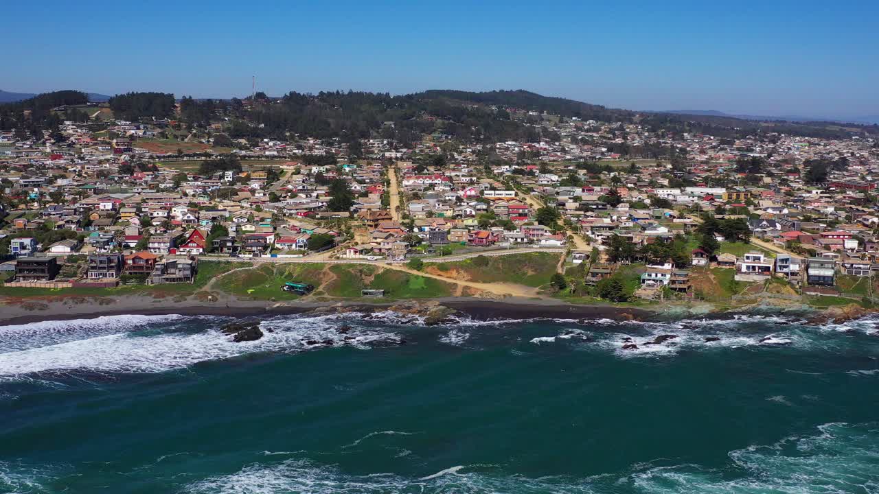 antena: vista de playa infiernillo en la ciudad de pichilemu también con vista al pueblo con playa de arena negra y casas en la playa tiro de drone chile pichilemu punta de lobos en colchagua cardenal caro