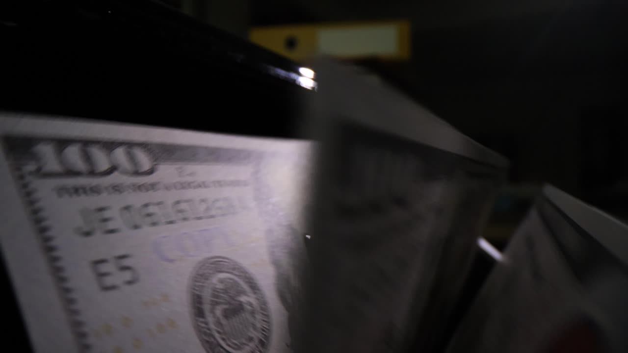 Bill counter processing dollar bills in dark bank premise
